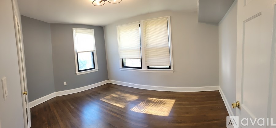 A room with wooden floors and two windows.