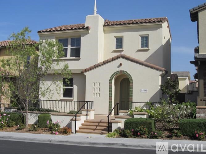 A white house with a black railing on the steps.