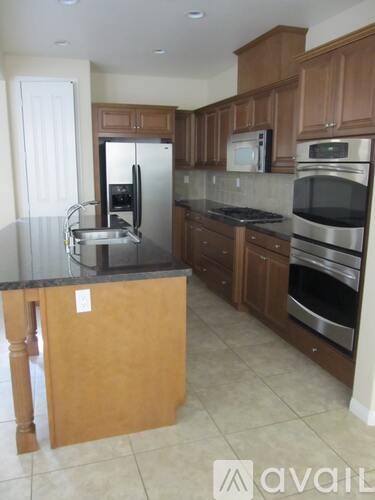 A kitchen with wooden cabinets and stainless steel appliances is available.