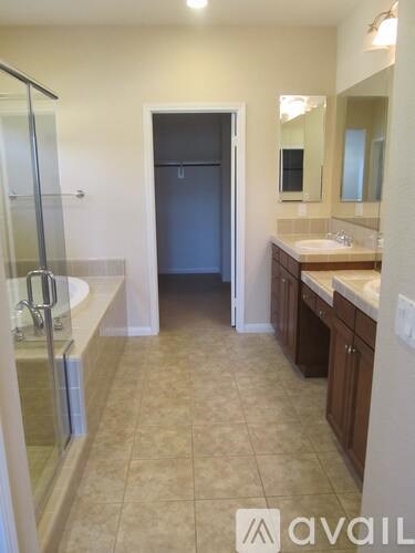 A bathroom with a sink, mirror, and a shower.