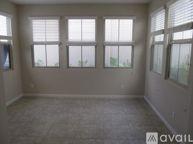 A room with four windows and tiled flooring.