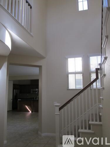 A white staircase with a black handrail.