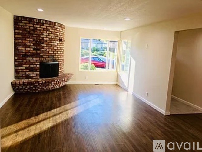 A living room with a brick wall and a flat screen TV.