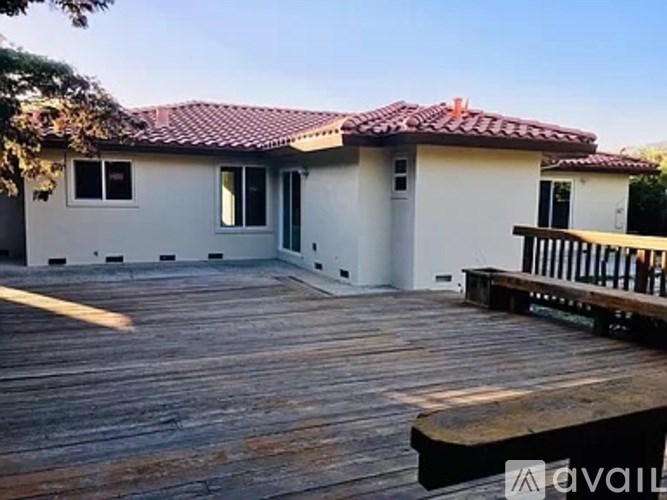 A house with a red tile roof and a wooden deck.