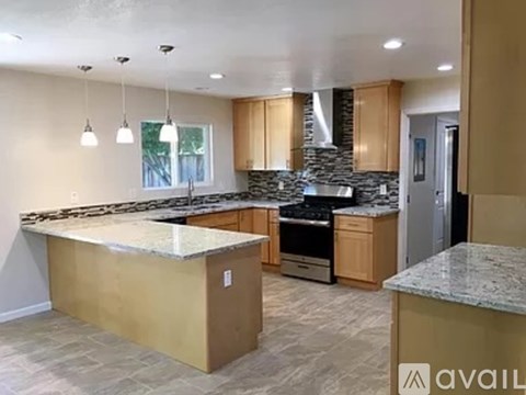 A kitchen with granite countertops and wooden cabinets.