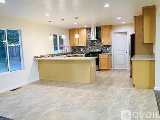 A kitchen with a stone backsplash and wooden cabinets.