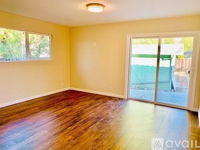 A room with wooden floors and a sliding glass door.