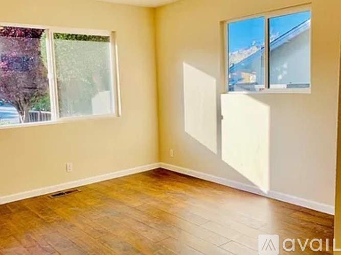 A room with a window and a door is available for rent.