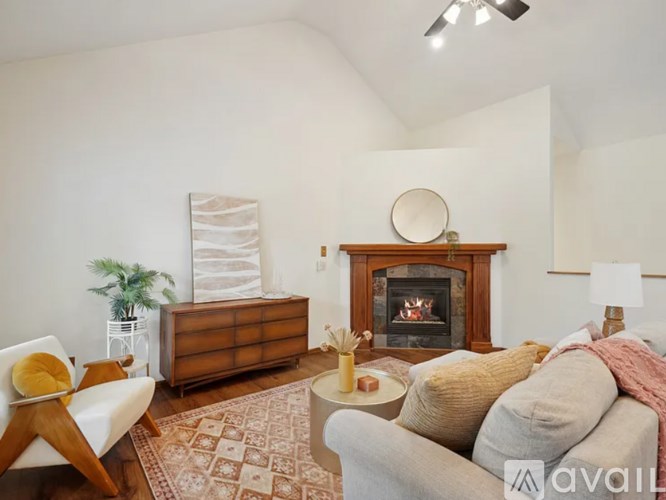 A living room with a fireplace, a couch, and a chair.
