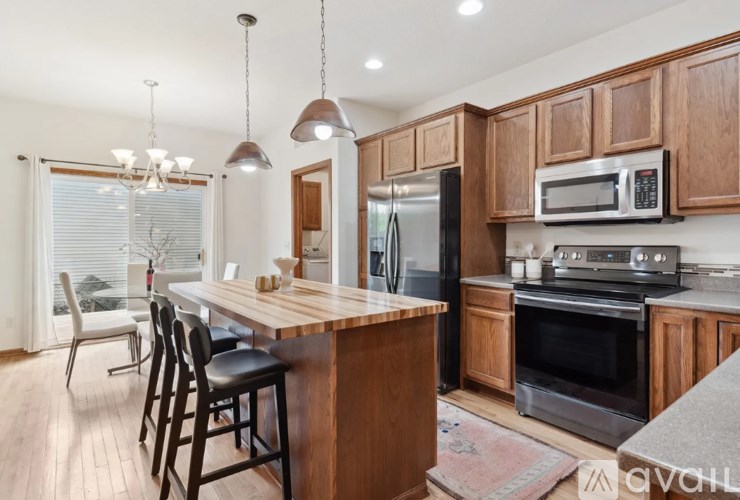 A kitchen with wooden cabinets and a bar area.