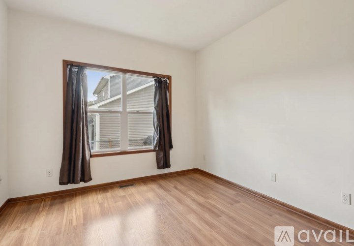 A room with a window and wooden flooring is available for rent.