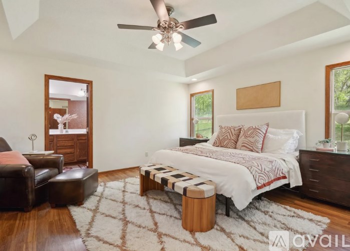 A bedroom with a bed, a couch, and a rug.