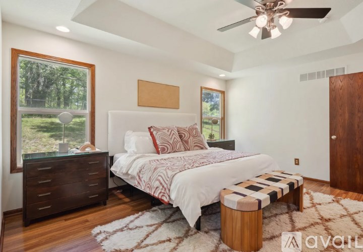 A bedroom with a bed, dresser, and window.