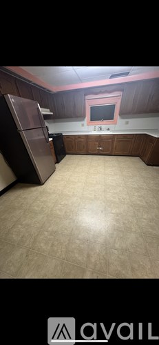 A kitchen with wooden cabinets and a refrigerator.