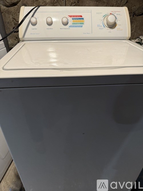 A white washing machine with a control panel on top.