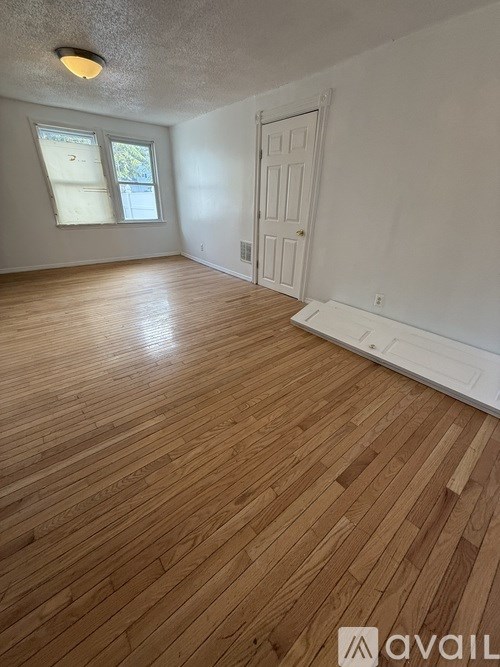 A room with wooden flooring and a white door.