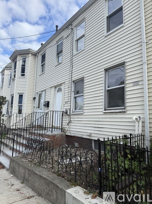 A row of houses with a black iron fence in front.