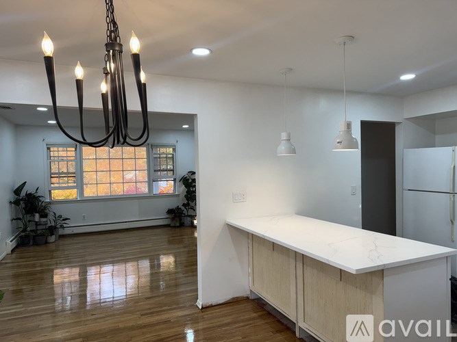A modern kitchen with a large island and pendant lights.