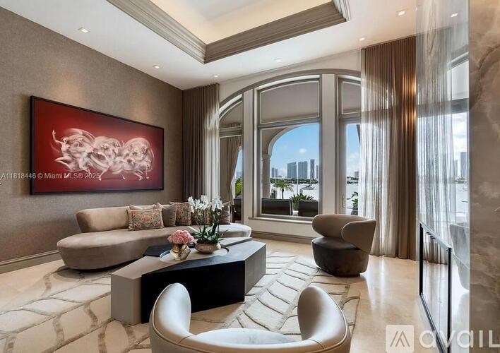 A living room with a large painting on the wall and a view of the city outside the window.