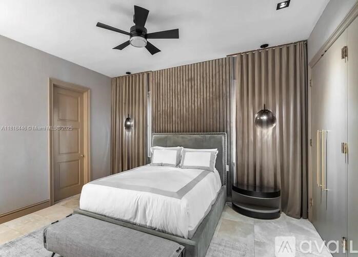 A bedroom with a large bed and a ceiling fan.