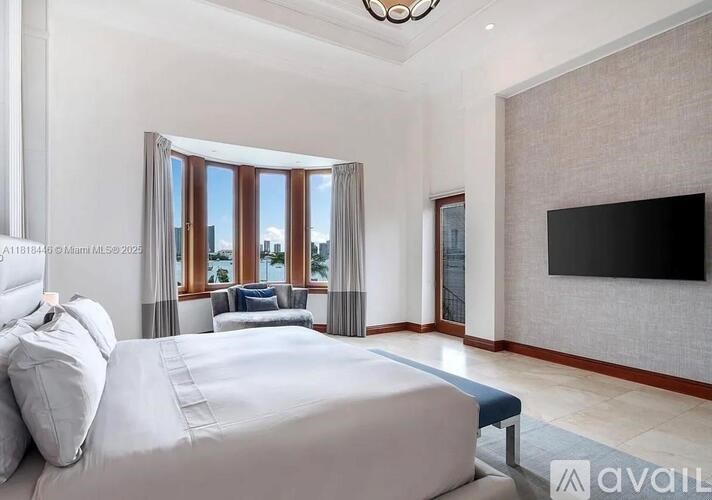 A bedroom with a large bed and a flat screen TV mounted on the wall.