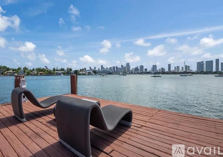 Two chairs are on a wooden deck overlooking a body of water.