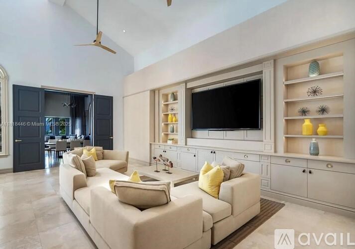 A living room with a large couch and a television on the wall.