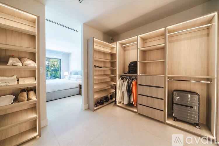 A spacious walk-in closet with wooden shelves and drawers.