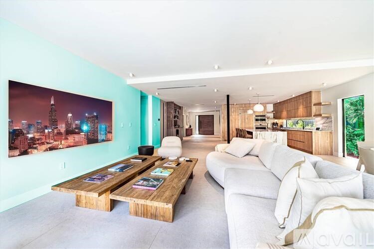 A living room with a large wooden coffee table and a large painting of a city skyline on the wall.