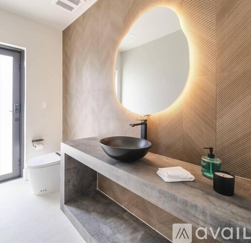 A bathroom with a round mirror and a sink.