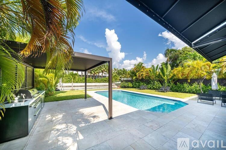 A pool area with a sun lounger and a table.