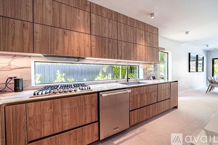 A modern kitchen with wooden cabinets and a stainless steel dishwasher.