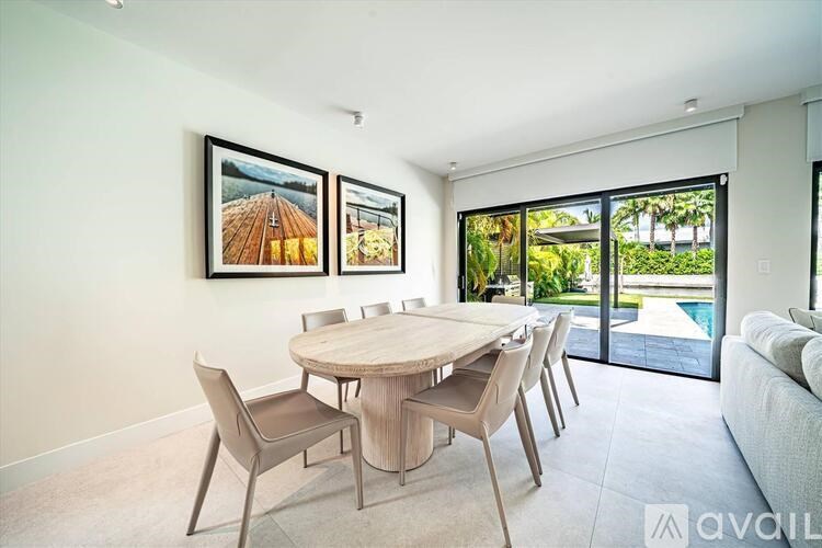 A dining room with a round table and chairs.