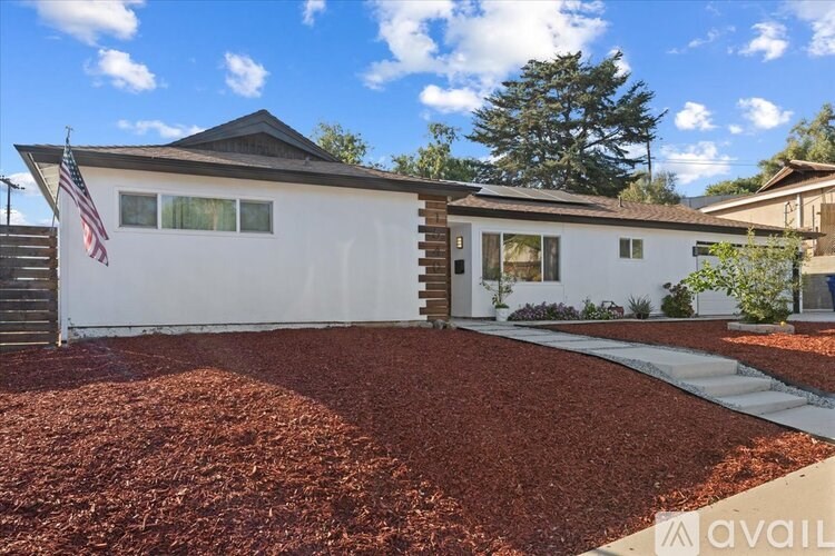 A house with a red mulch in front and an American flag on the left.