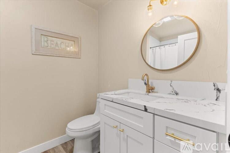 A bathroom with a white toilet and a marble countertop.
