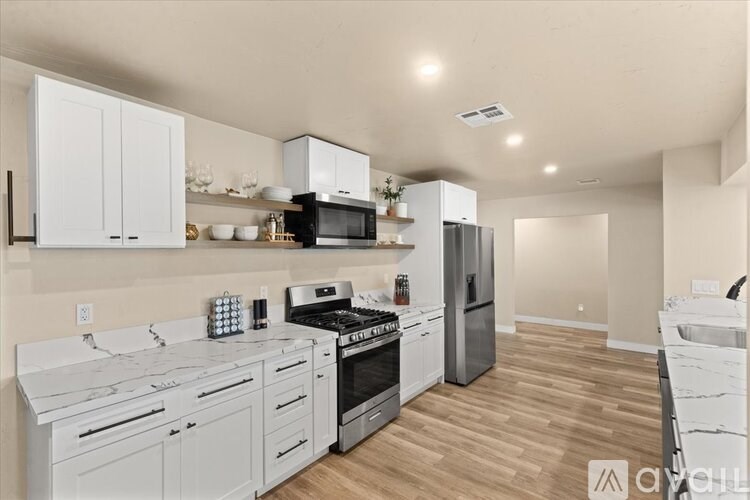 A modern kitchen with white cabinets and appliances.