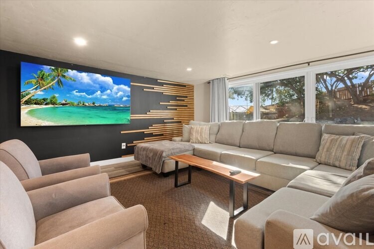 A living room with a large screen displaying a beach scene.