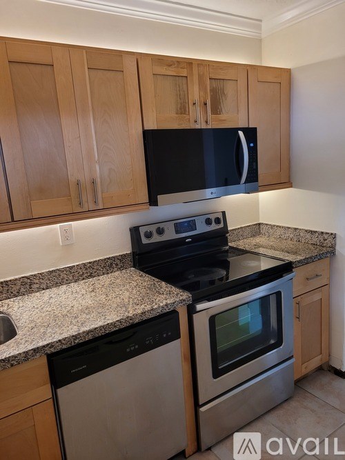 A kitchen with a black microwave above a stove and a dishwasher to the left.