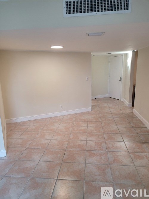 A room with tiled flooring and a doorway leading to another room.