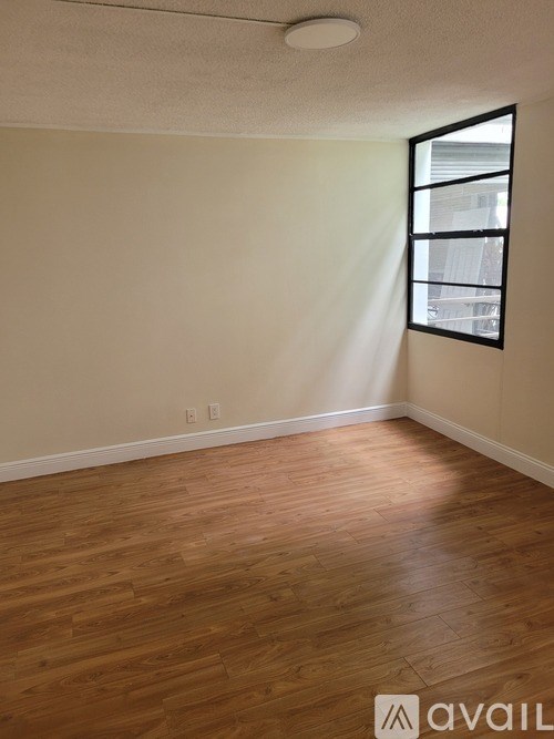 A room with wooden flooring and a window.
