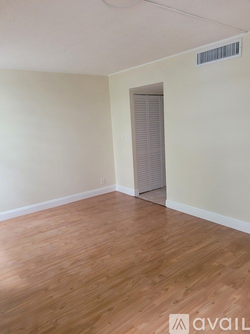 A room with wooden flooring and a closed door.