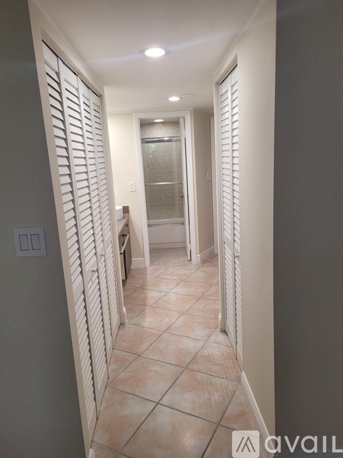 A hallway with a tiled floor and white walls.