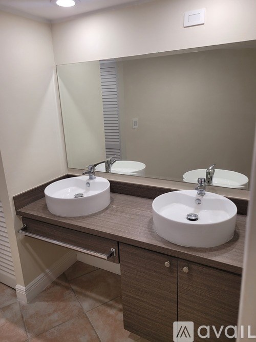 A bathroom with two sinks and a large mirror.