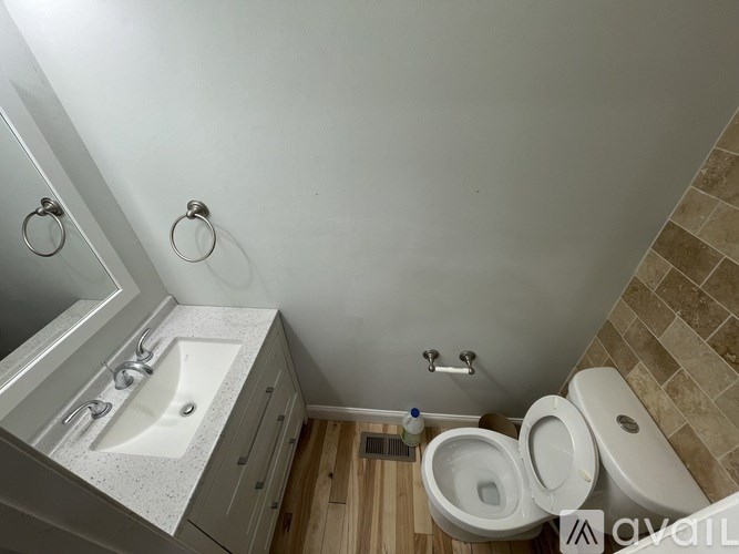 A bathroom with a toilet, sink, and a shower.