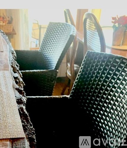A black woven chair is in the foreground of the image.