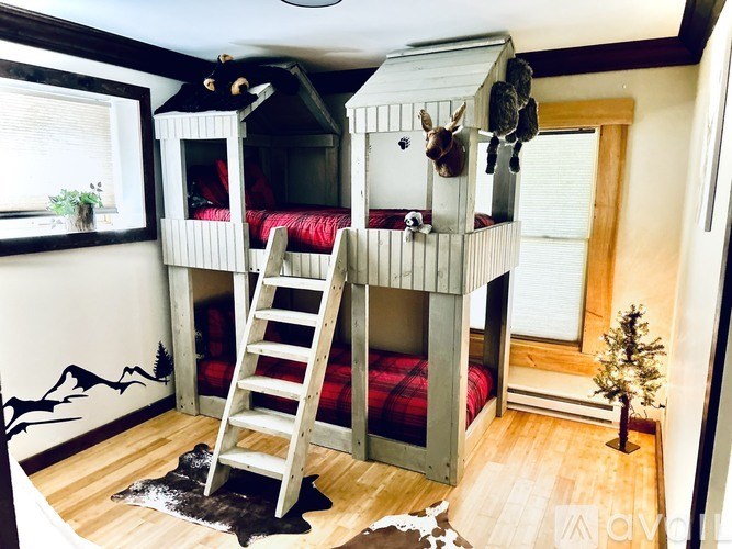 A room with a bunk bed and a ladder.