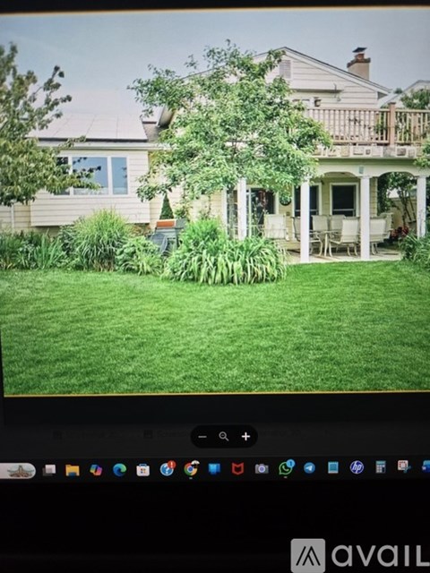 A house with a white porch and a green lawn.