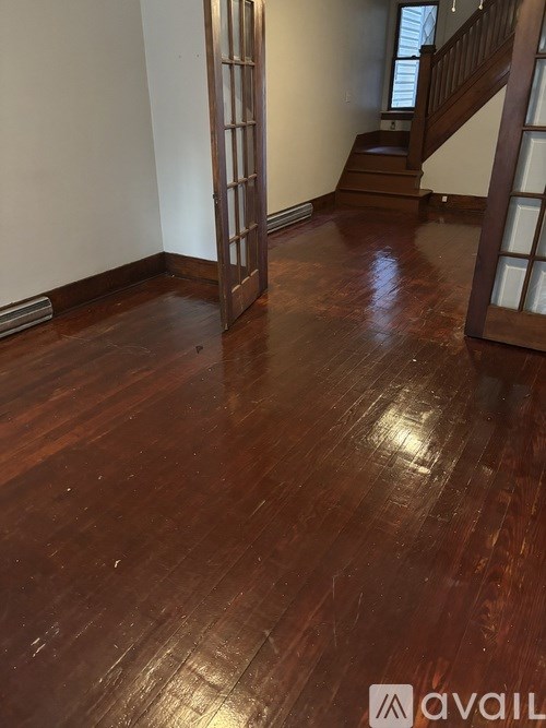 A room with wooden floors and a staircase.