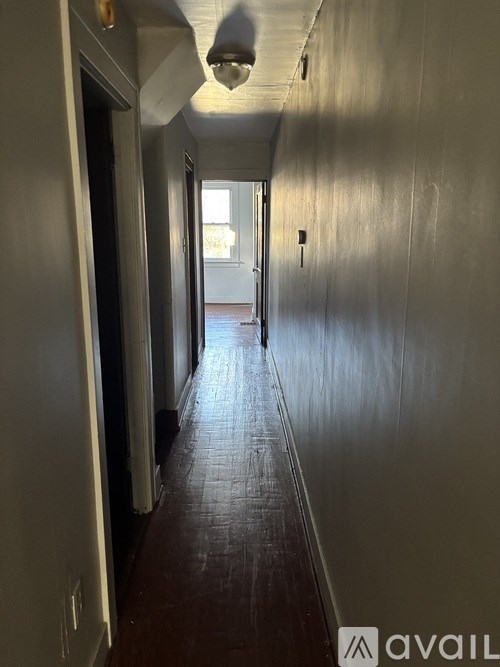 A long hallway with a person walking towards the end.