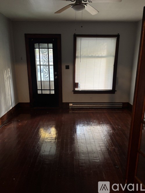 A room with a wooden floor and a ceiling fan.